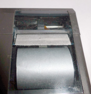 Принтер для калькулятора - Mini Electro Printer Casio FP-10 - с трудом, в середине верхней части, через мутноватый пластик, видно печатающую головку.